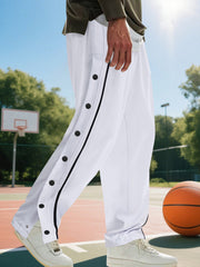 Men's white loose-fit track pants with side snap buttons and pockets.