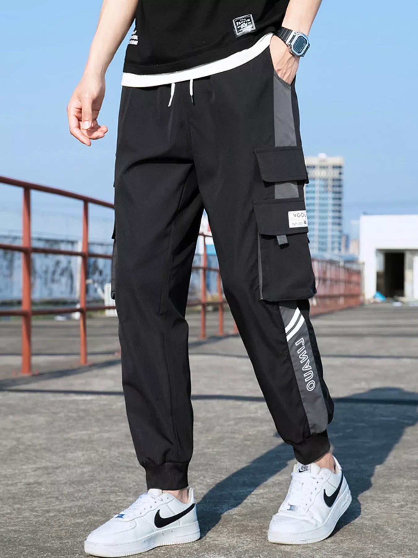 Men's black gray cargo pants with a drawstring waist and pockets.