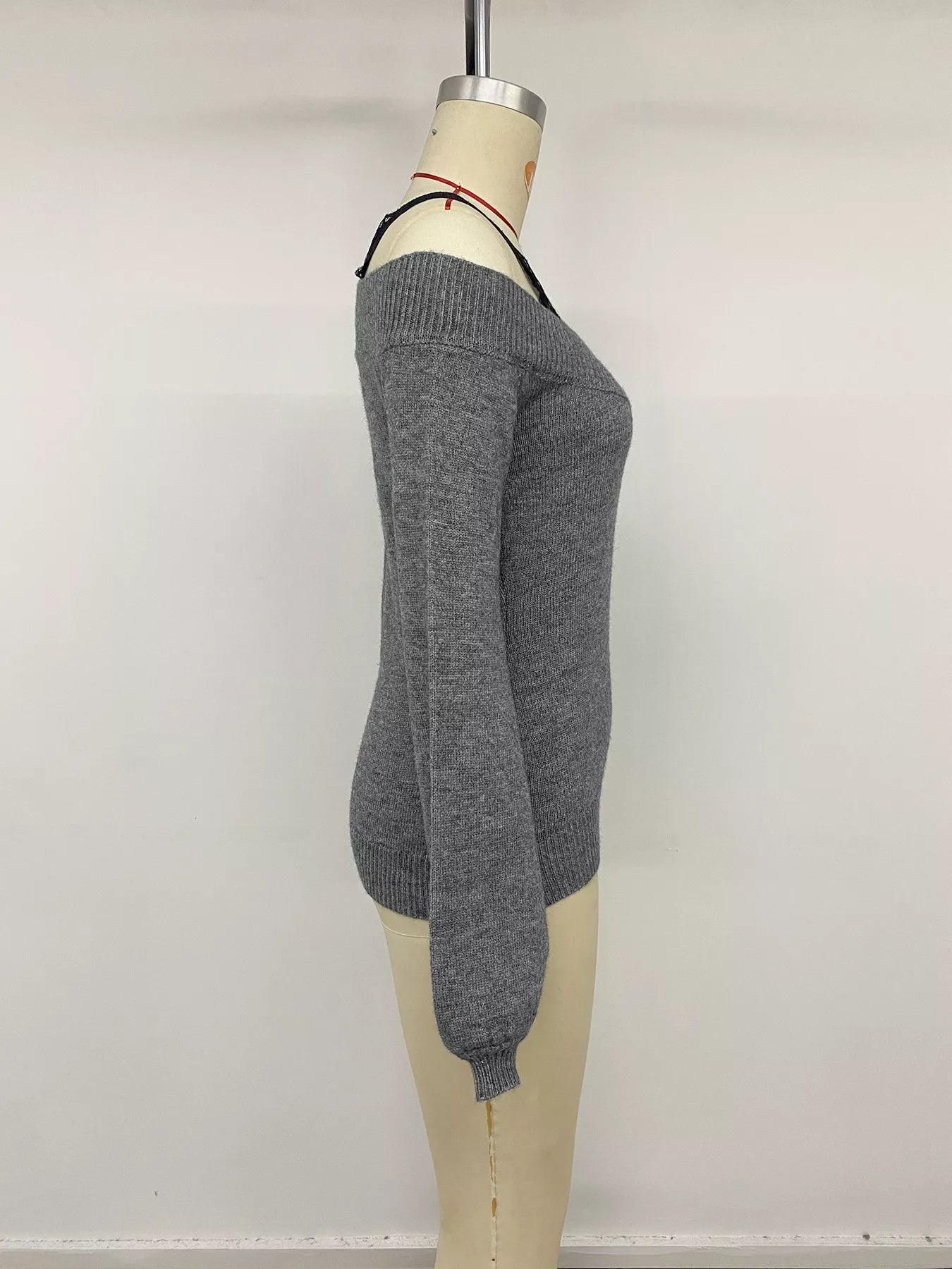 Side view of dark grey off shoulder lace trim sweater displayed on mannequin