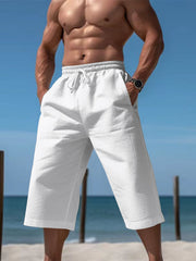 Men's white cropped casual pants with a drawstring waist and pockets.