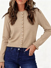 Front view of khaki ruffle trimmed button down cardigan with ruffled cuffs and dark jeans