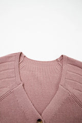 Flat lay close-up of the V-neckline and ribbed knit on a dusty pink cardigan