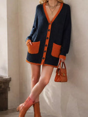 Side leaning view of the navy cardigan with orange trim, buttons, and large patch pockets