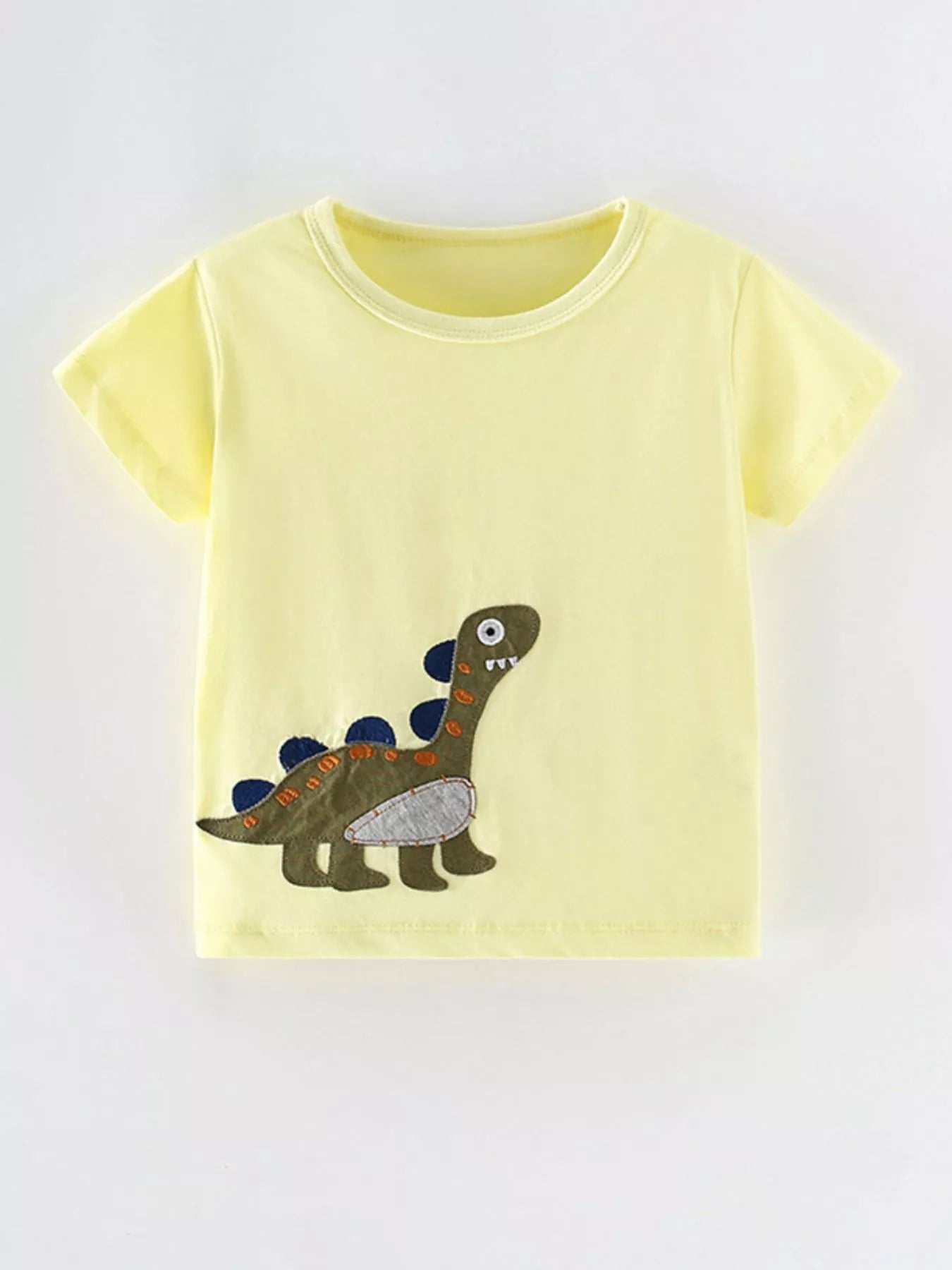 Front view of a light yellow children's short sleeve shirt with a green dinosaur applique near the hem
