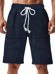 Men's navy blue textured shorts with a drawstring waist and pockets.