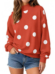 Front view of red mock neck oversized sweatshirt with large white polka dots on model