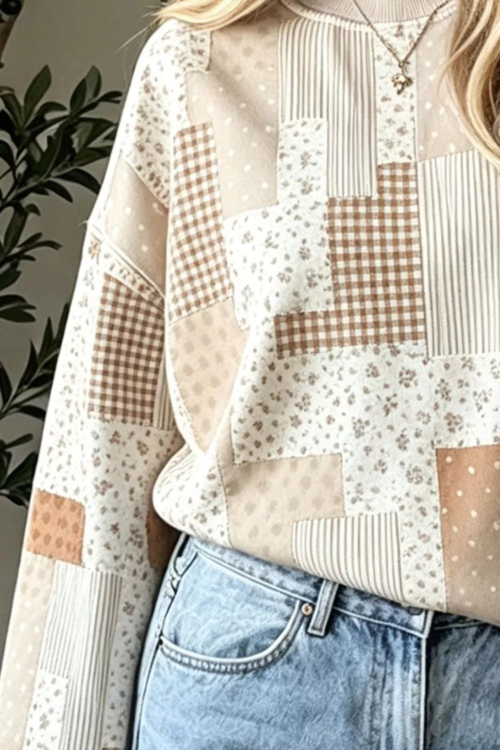 Close front detail of tan vintage patchwork dropped shoulder sweatshirt showing mixed panels