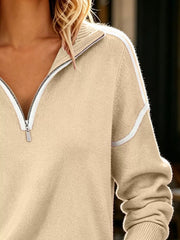 Close up of tan quarter zip sweater showing zip collar and white shoulder piping