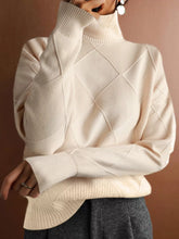 Front torso view of a cream turtleneck sweater with a tonal diamond pattern