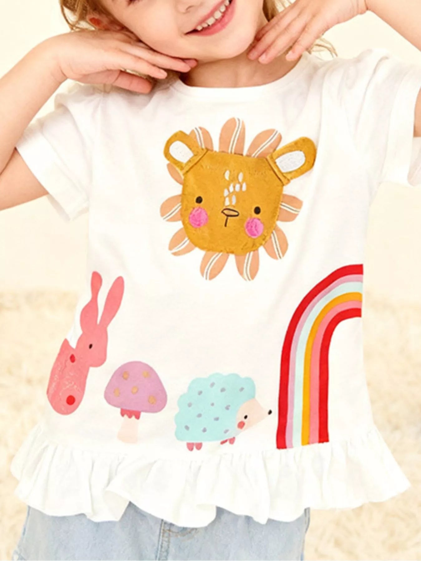 Children's white T-shirt featuring a cartoon animal graphic and ruffle hem.