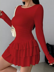 Red long sleeve mini dress worn in a side view showing the ruched waist and tiered ruffle skirt