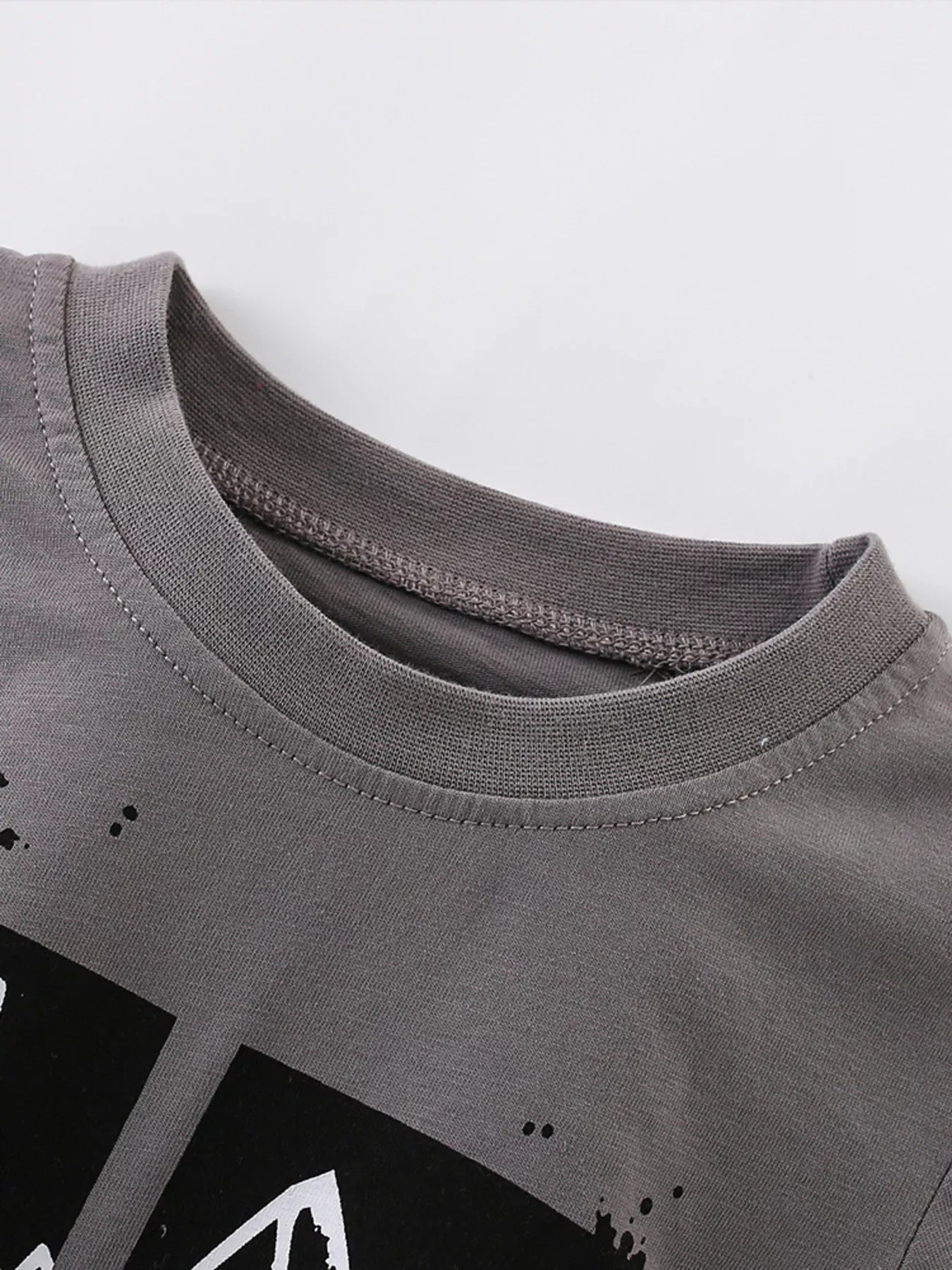Close view of the ribbed crew neck on a dark gray children's t shirt