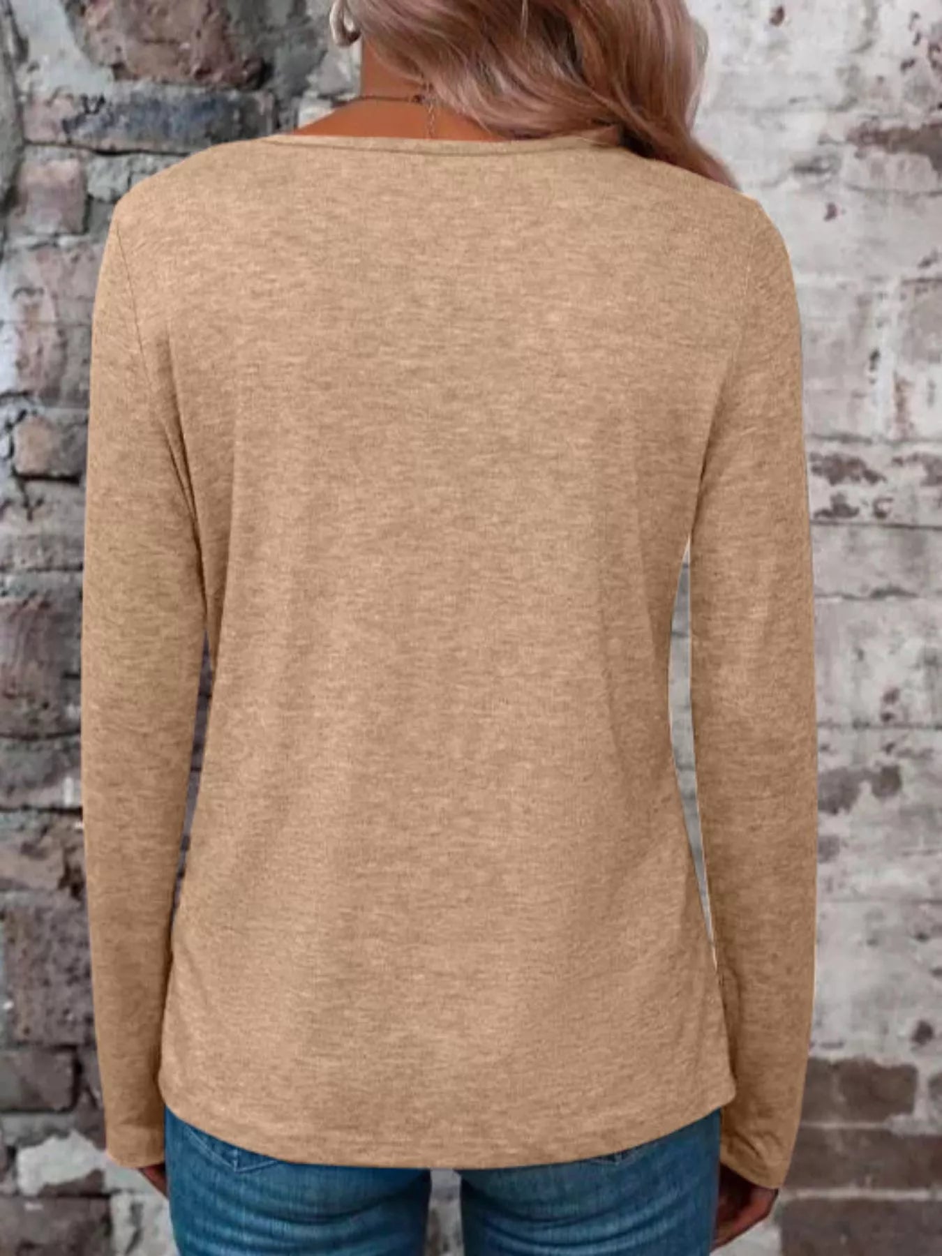 Back view of a tan long-sleeve V-neck shirt on a model.