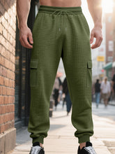 Men's army green textured cargo joggers with a drawstring waist and pockets.