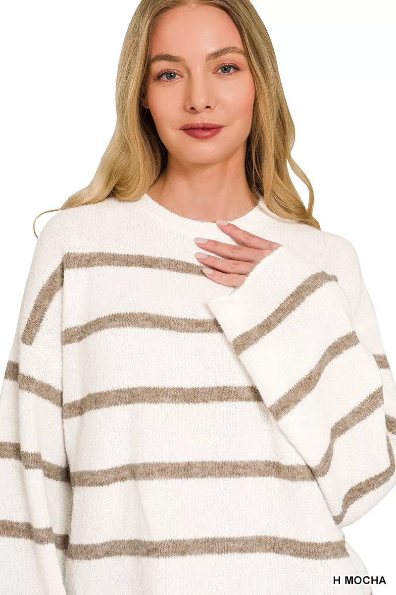 Front view of cream striped sweater with mocha stripes, hand resting on chest.
