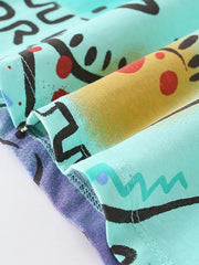 Close-up of folded hem and stitching showing multicolor dinosaur print on children's t-shirt