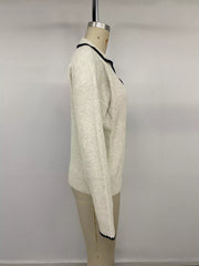 Side view on a mannequin of a cream sweater with black scalloped collar and cuff trim