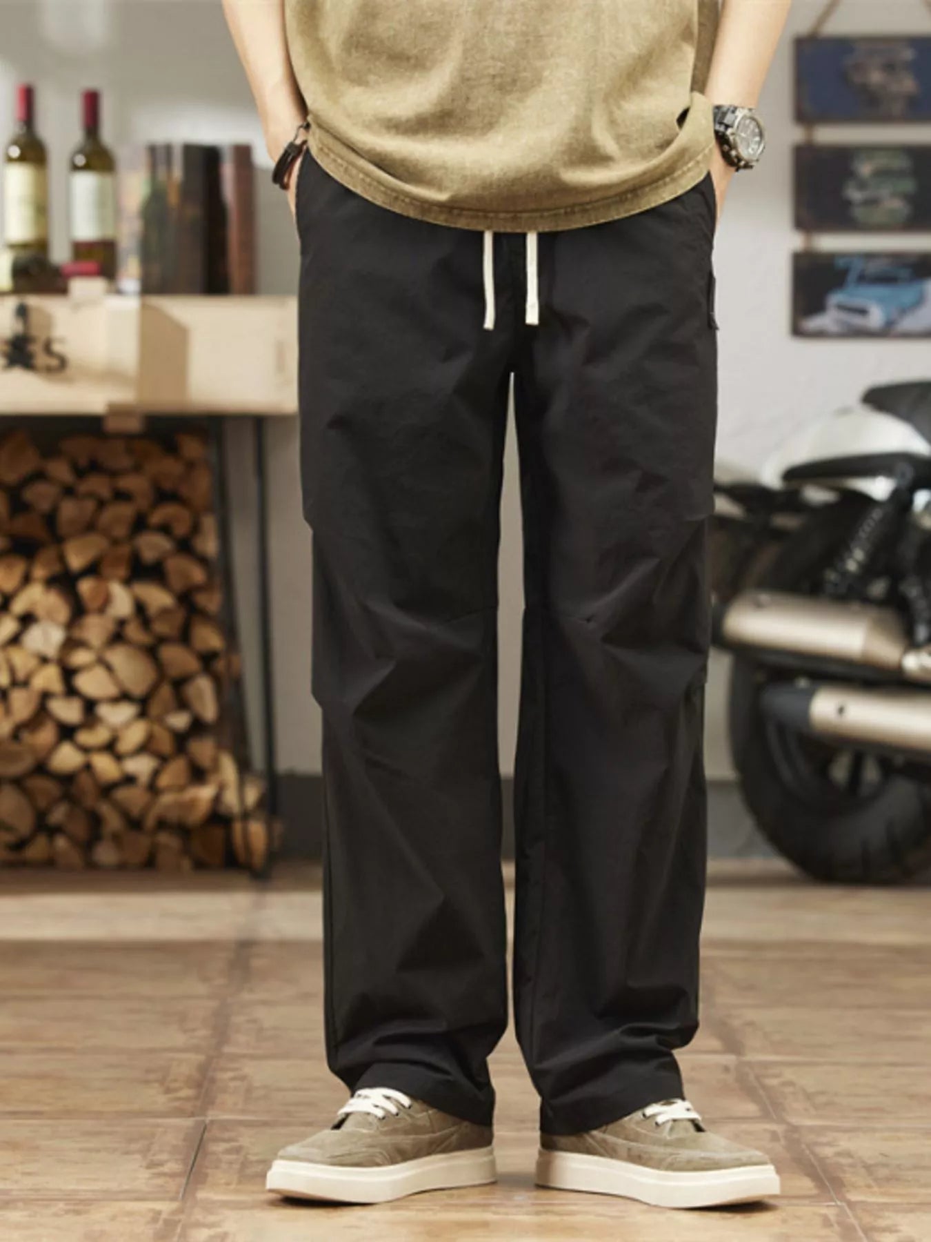 Men's black relaxed-fit casual pants with a drawstring waist and pockets.