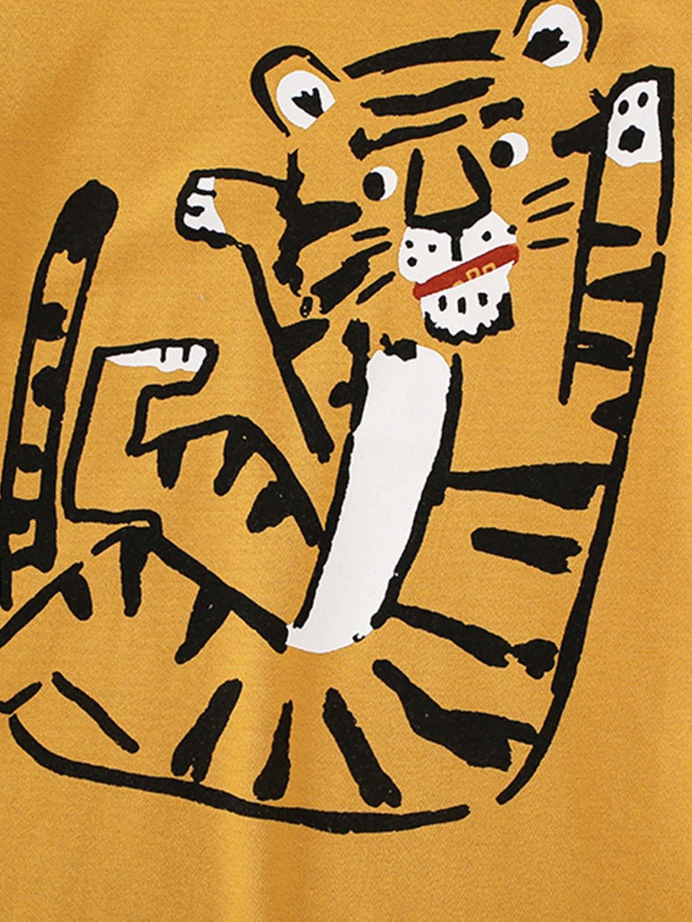 Close-up detail of the cartoon tiger graphic on the children's mustard t-shirt