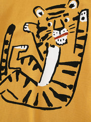 Close-up detail of the cartoon tiger graphic on the children's mustard t-shirt