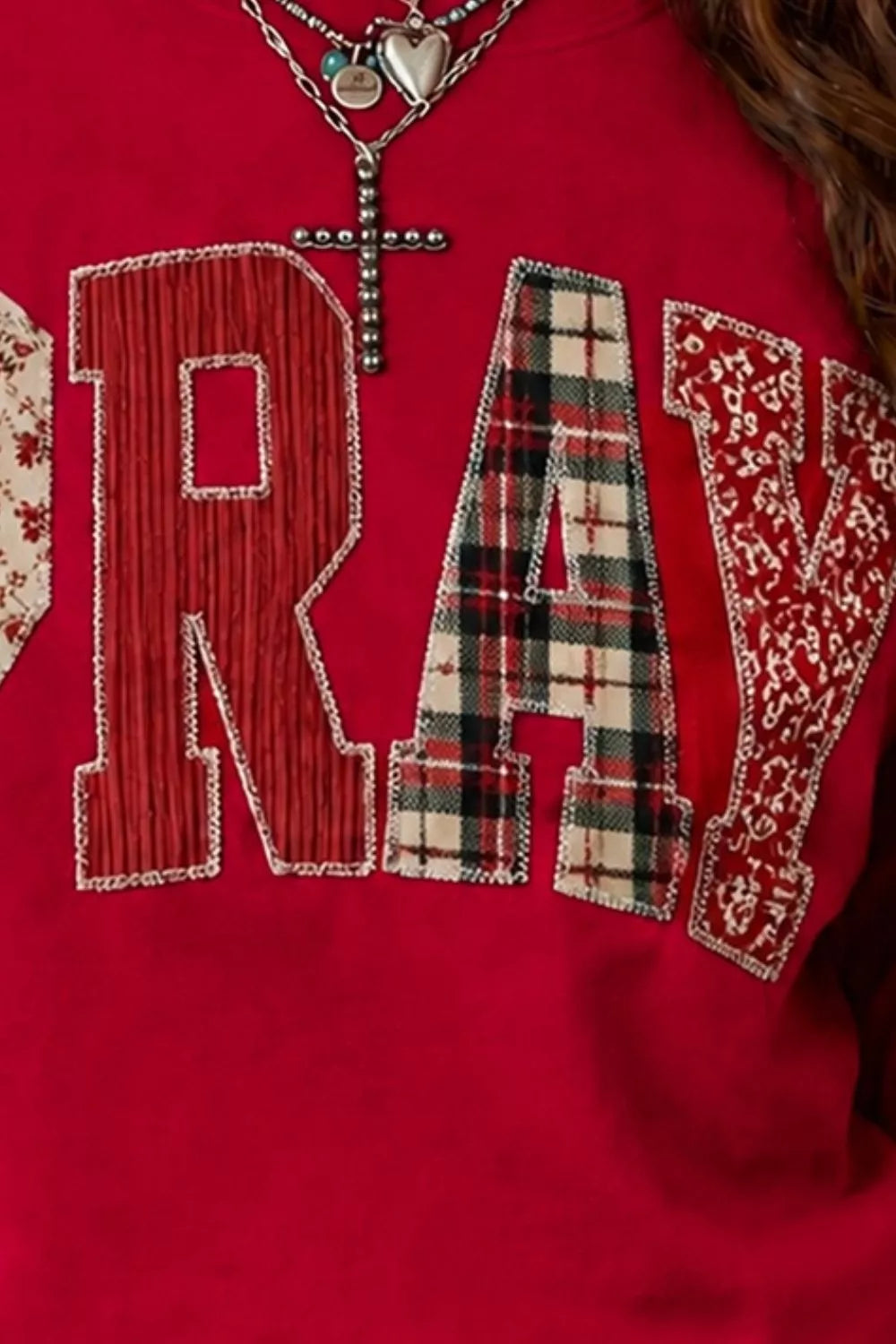 Close detail of scarlet western sweatshirt showing striped, plaid and patterned patch letters