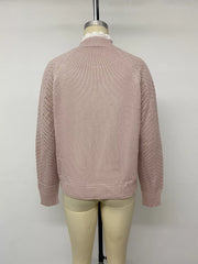 Back view on a mannequin of a pink sweater with openwork sleeves and ribbed hem