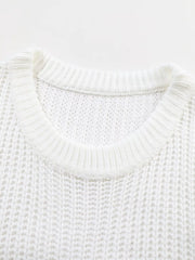 Close view of white ribbed knit sweater showing round neckline and open knit texture.