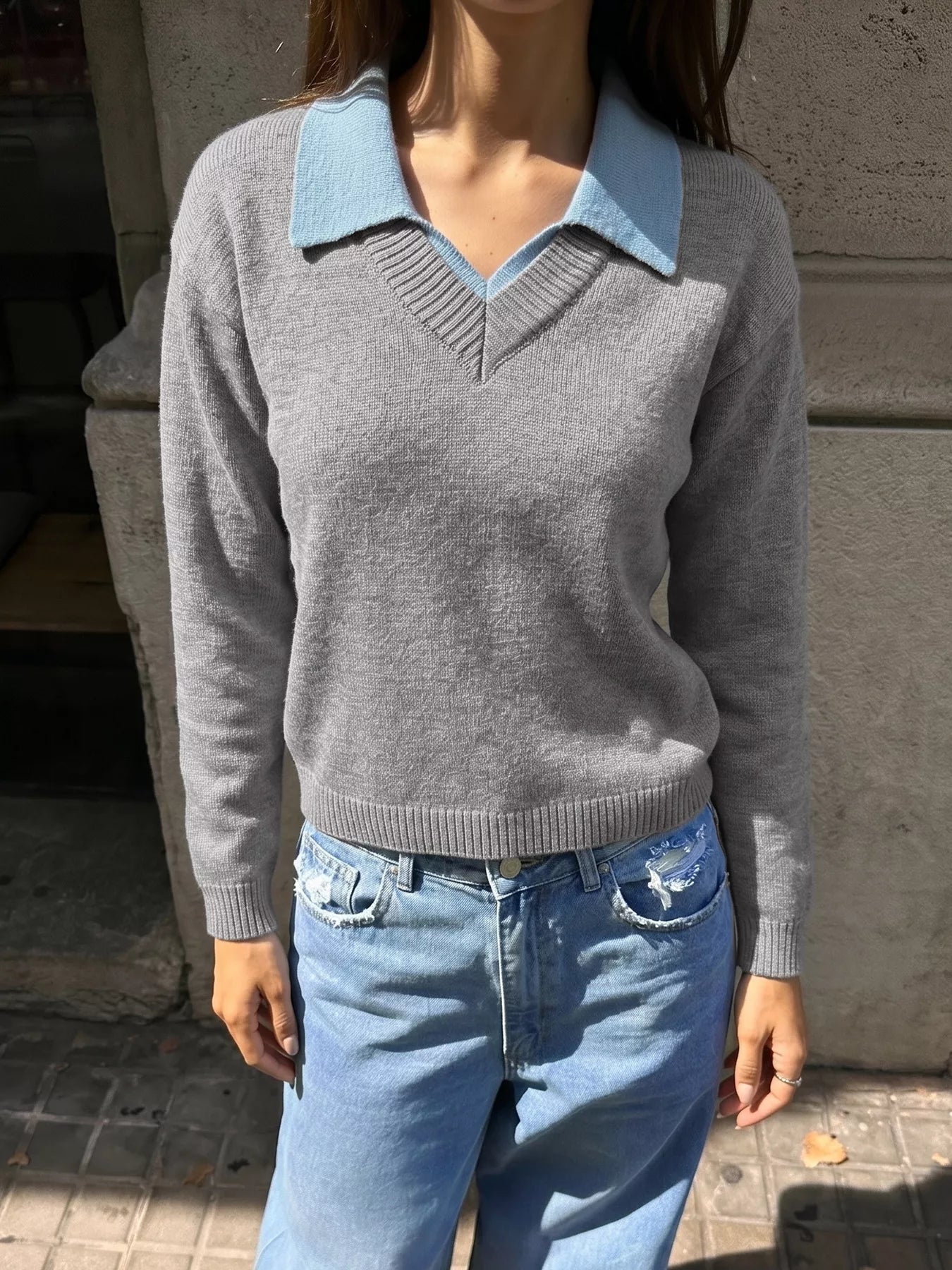 Standing front view of the gray sweater with a light blue contrast collar and jeans