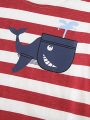 Close-up detail of the smiling navy whale graphic on the red striped children's t-shirt