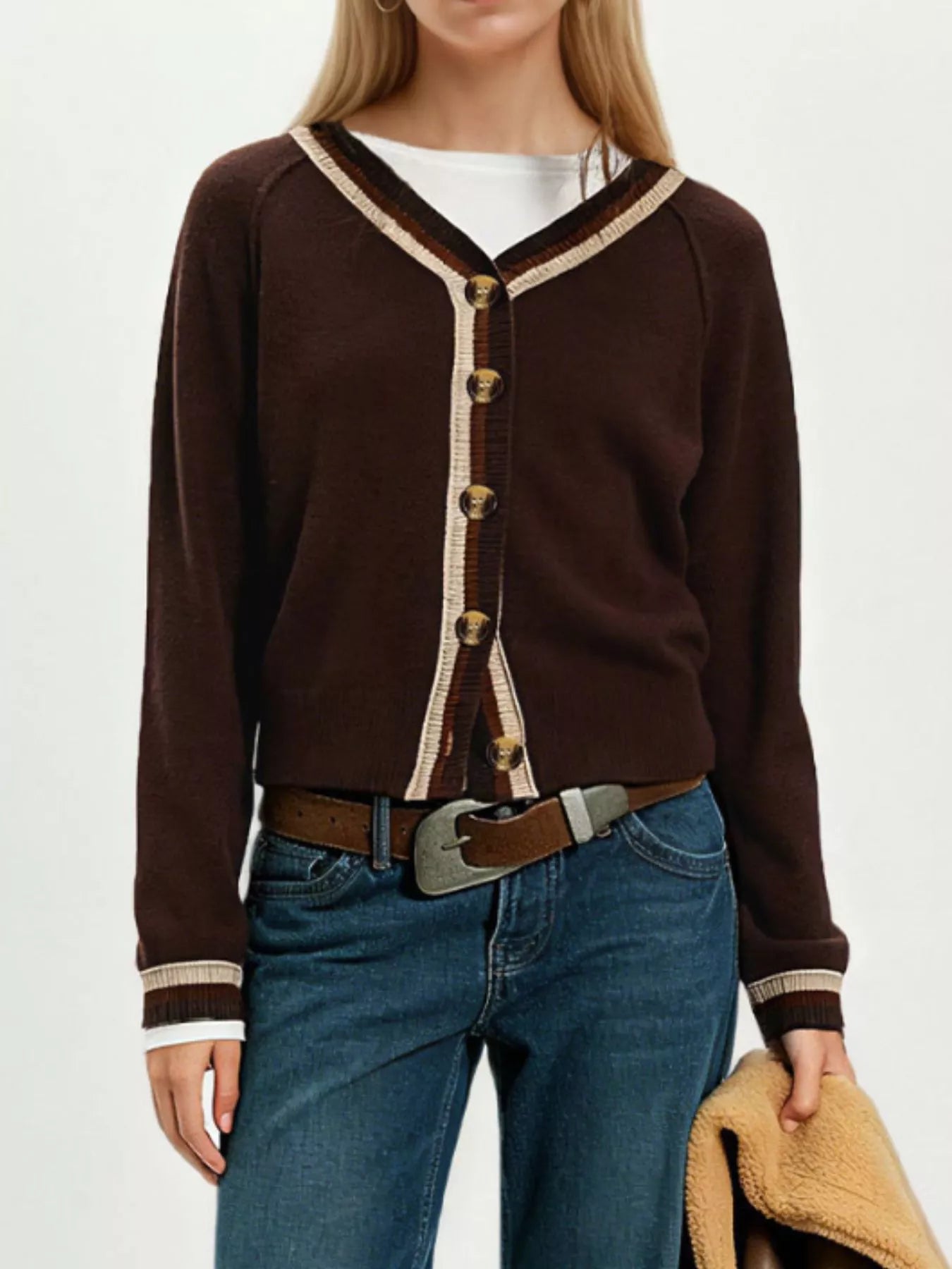 On-model front view of brown button down cardigan with cream striped trim and tortoiseshell buttons