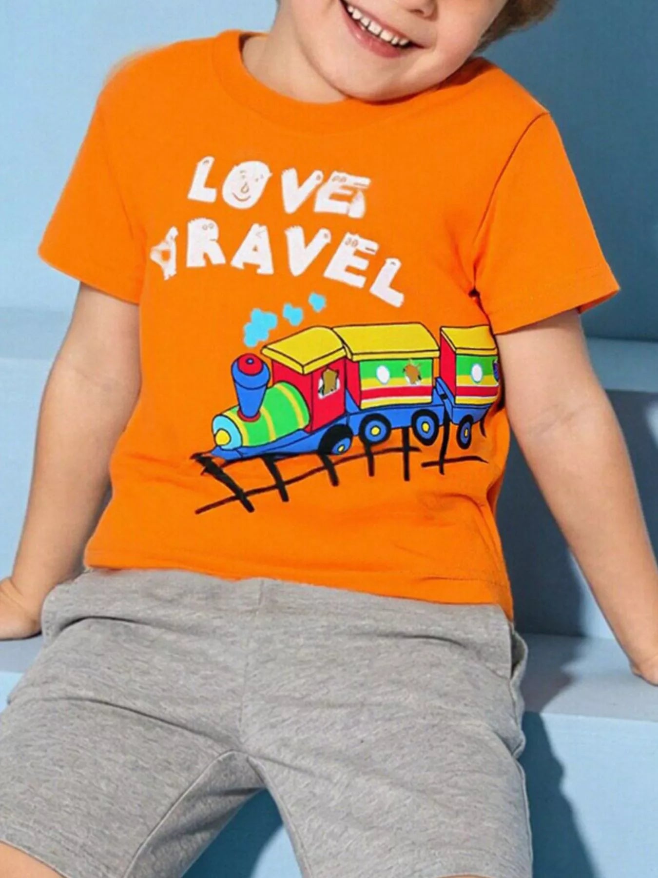 Children's orange T-shirt featuring a train graphic with Love Travel wording.