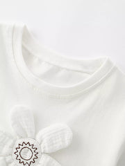 Close-up of white children's t-shirt neckline and upper edge of padded flower applique