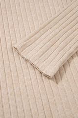 Close-up detail of a beige ribbed knit fabric showing the long sleeve top’s texture and folded edge