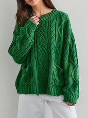 Front view of green cable knit sweater with front pockets and white pants