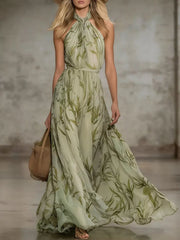 Front view of a matcha leaf print sleeveless chiffon maxi dress with a tied halter neck