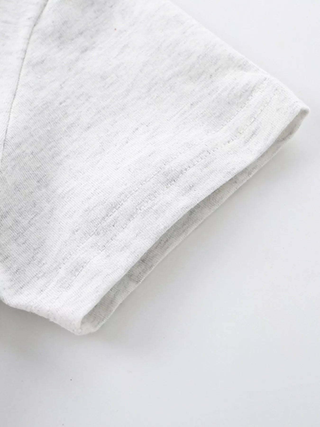 Close-up of the light gray heathered short sleeve hem with neat double stitching