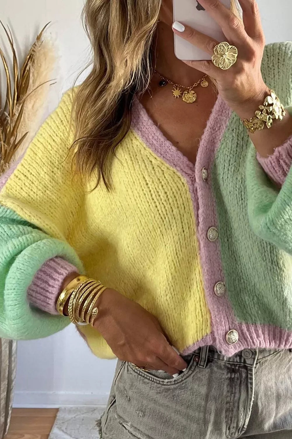 Close front view of the patchwork cardigan showing its gold buttons and V neck