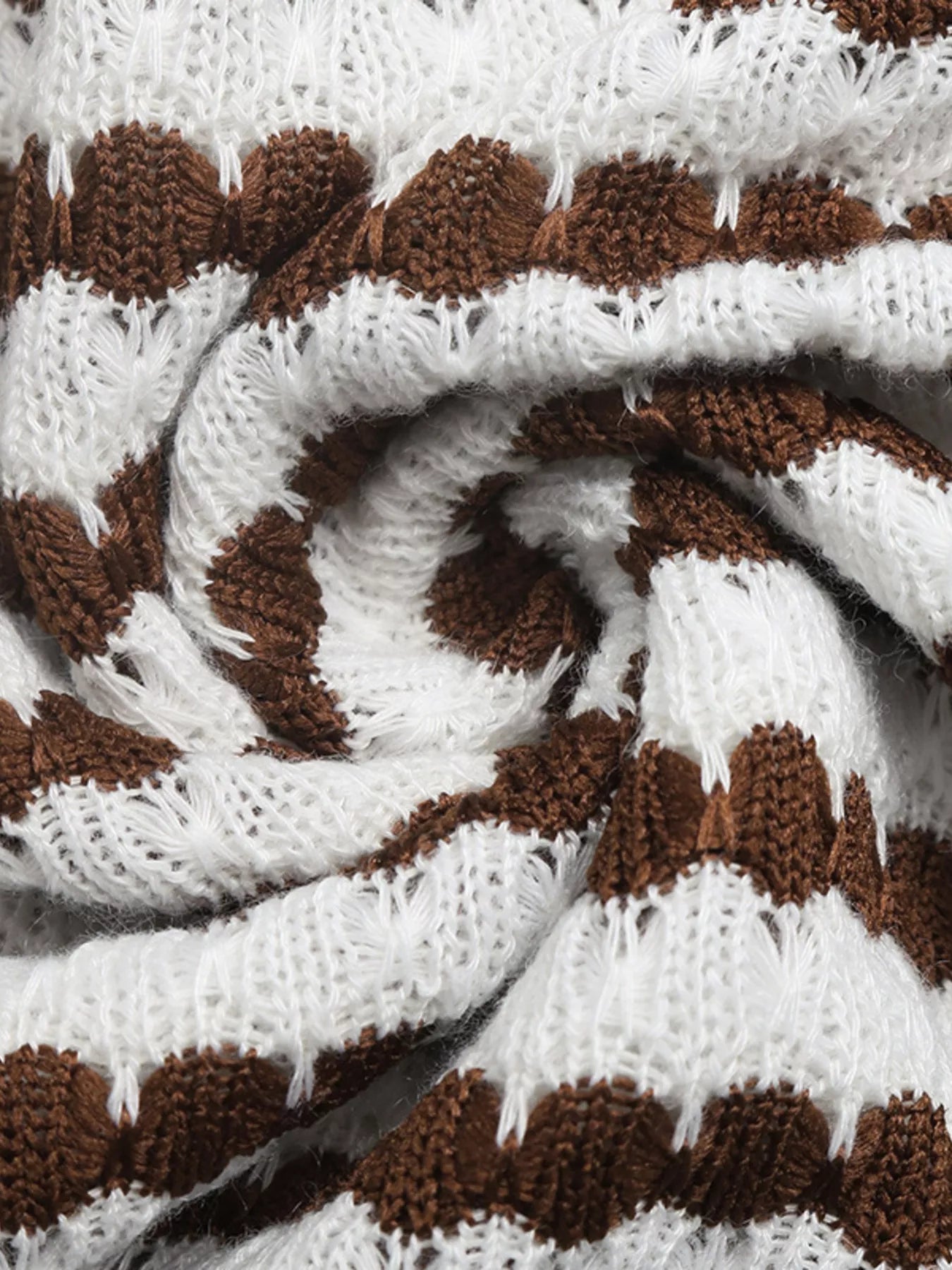 Close up of swirled brown and white striped knit fabric showing texture of sleeveless bodycon dress