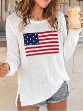 White long sleeve sweater with American flag graphic, worn on model holding iced drink