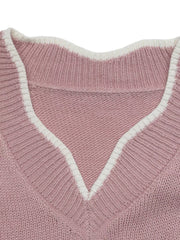 Close up of the pink sweater V neck with white trim and ribbed knit detail.