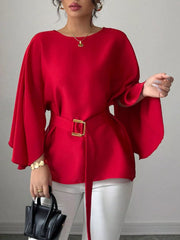 Red batwing sleeve blouse front view with one hand raised showing wide flowing sleeve