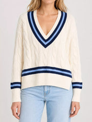 On-model front view of a cream cable knit sweater with navy and light blue striped trim