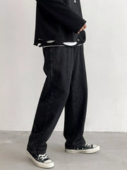 Men's Black loose fit wash jeans on model, side view while walking.