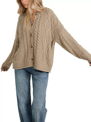 Front view of khaki cable knit button down cardigan fully buttoned with blue jeans