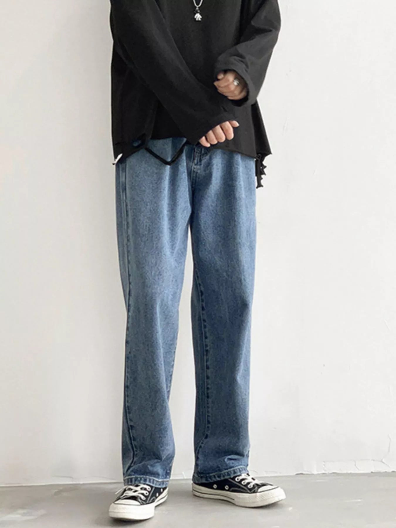 Men's Light Blue loose fit wash jeans on model, front view with black top.