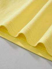 Close view of the hem stitching and soft yellow fabric on the children's t-shirt