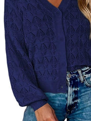 Side close view of navy openwork knit cardigan showing button front and hem.