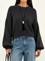 On-model front view of a black oversized chunky knit sweater with balloon sleeves