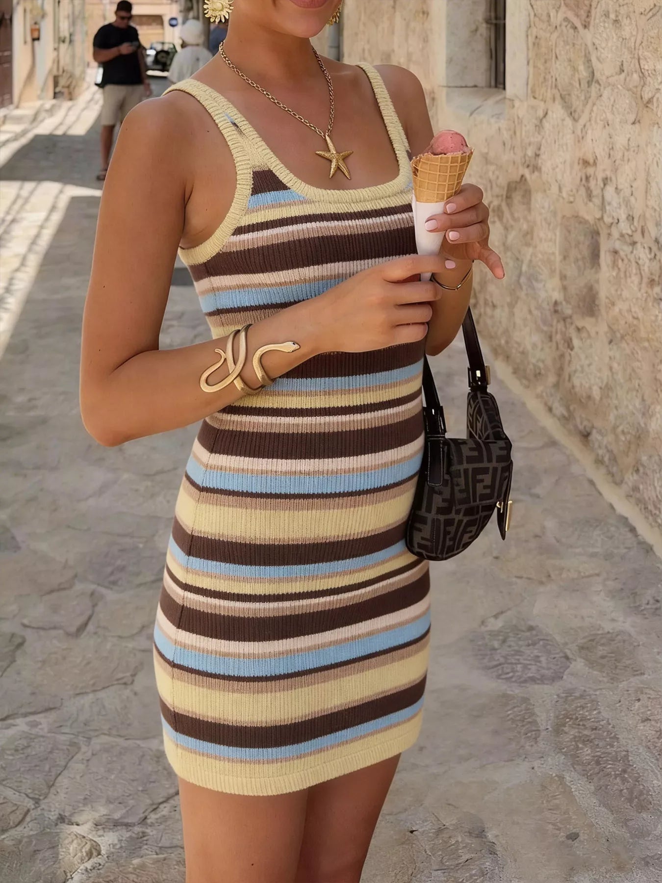 Front view of a striped scoop neck knit mini dress while holding an ice cream cone.