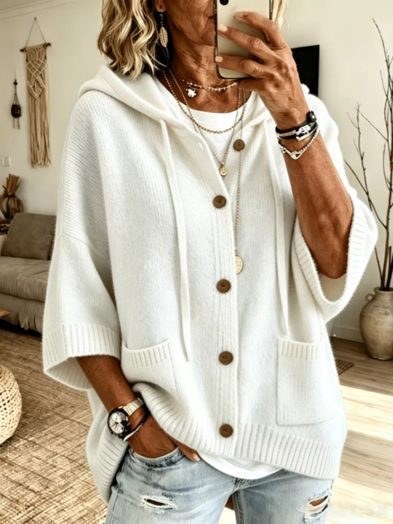 White hooded knit cardigan with brown buttons and patch pockets shown from the front on model